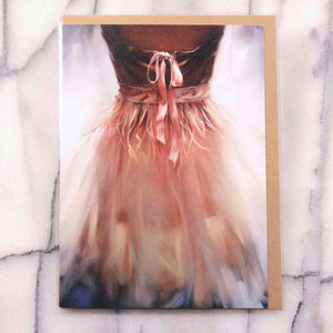 
                  
                    Load image into Gallery viewer, Ballerina Greeting Card, view of a pink organza dress with ribbons and bow against a glowing background, front card view, with envelope in protective sleeve
                  
                