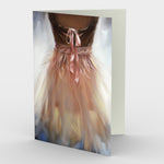 Ballerina Greeting Card, view of a pink organza dress with ribbons and bow against a glowing background, front card view, blank interior